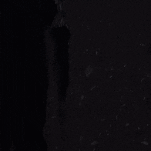 a person is standing in the dark with a black background