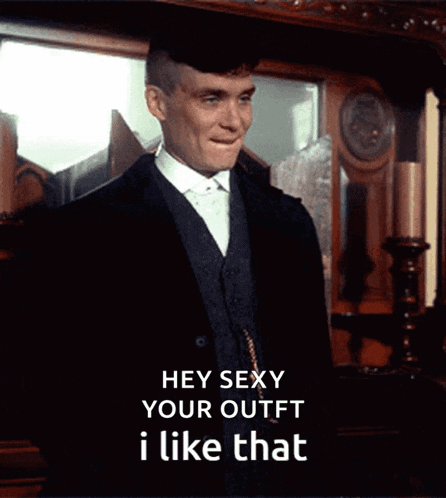 a man in a suit is standing in front of a mirror and says hey sexy your outfit i like that