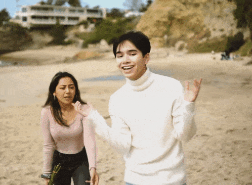 a man in a white sweater stands next to a woman
