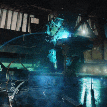 a man wearing a welding mask is welding a piece of metal in a dark room