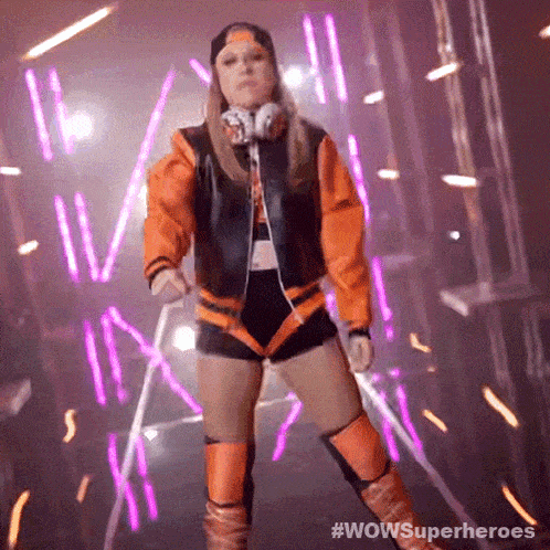 a woman in a superhero costume is dancing in a dark room with neon lights behind her .