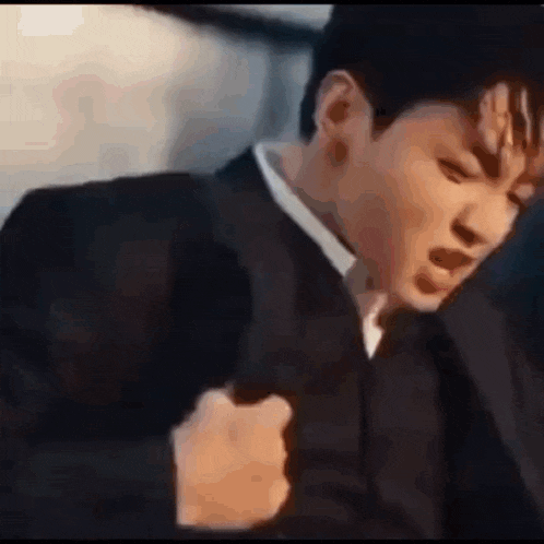 a man in a suit and tie is holding a gun .