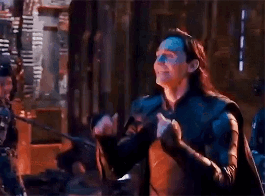 a man with a bandana on his head is clapping his hands in a room .
