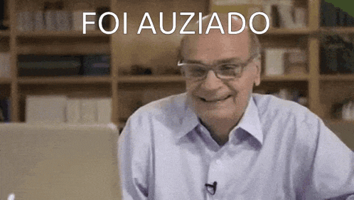 a man wearing glasses is smiling in front of a sign that says " foi auzado "