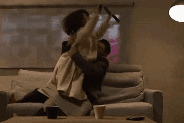 a man and a woman are hugging on a couch in front of a projector screen