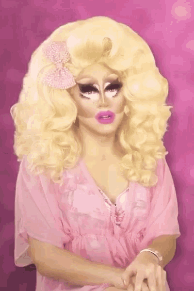 a drag queen wearing a pink dress and blonde hair
