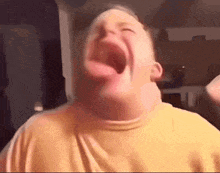 a man is making a funny face with his mouth wide open .