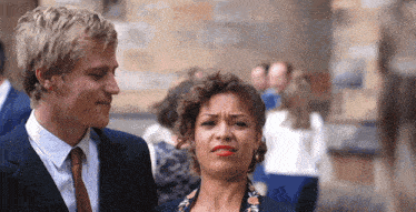 a man and a woman are standing next to each other and the woman is making a face