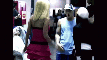 a woman in a pink dress stands next to a man in a blue shirt