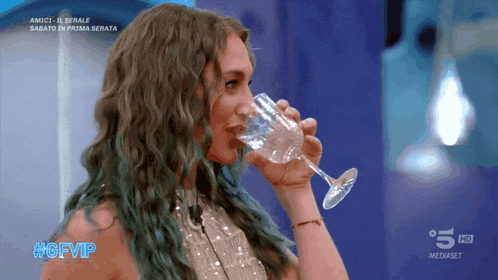a woman drinking from a glass with the hashtag #gfvip on it