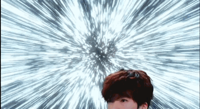 a man is standing in front of a burst of light coming out of his head .