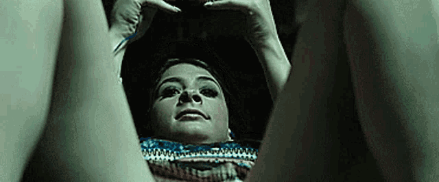 a woman is laying on her stomach with her legs crossed and her hands on her head .