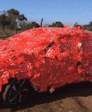 a car is wrapped in red paper that says cc