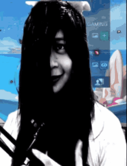 a woman with long black hair is holding a pair of scissors in front of a screen that says gaming