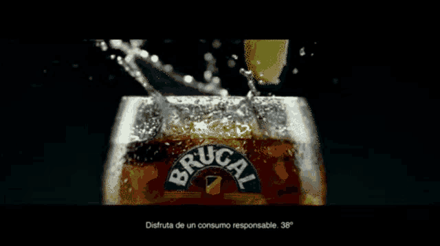 a glass of brugal is being poured into a glass