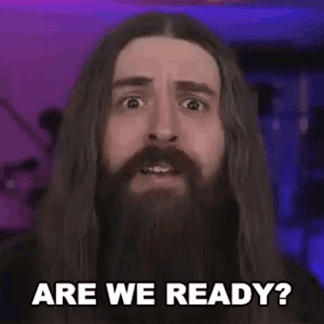 a man with a beard and long hair is asking are we ready .