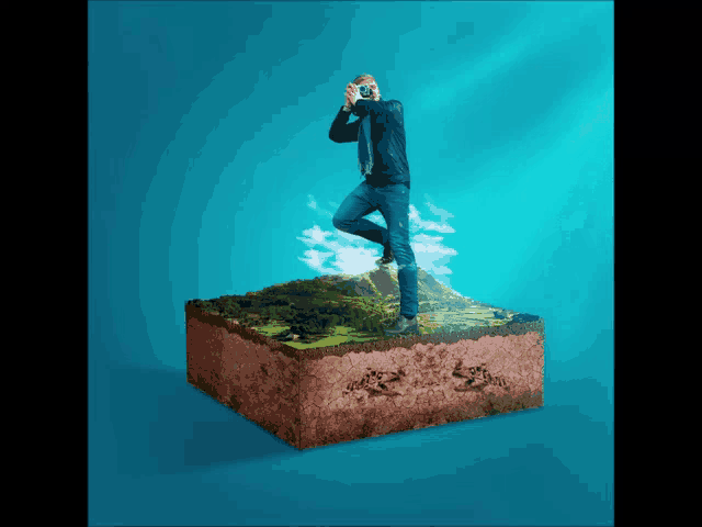 a man standing on a piece of dirt taking a picture with a camera