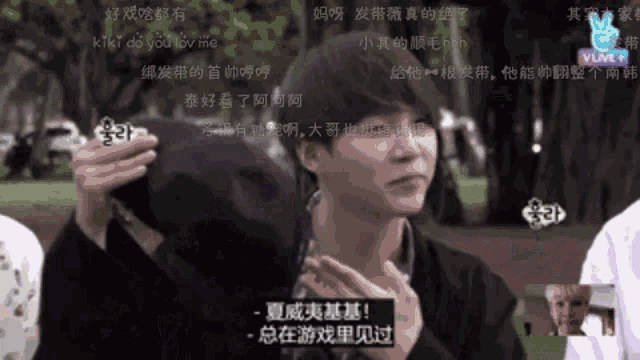 a man in a black jacket is holding something in his hand and says kiki do you love me in a foreign language