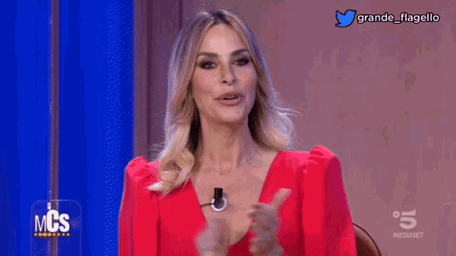 a woman in a red dress says buonasera on a screen