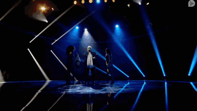 a group of people are dancing on a stage with a arrow pointing to the right