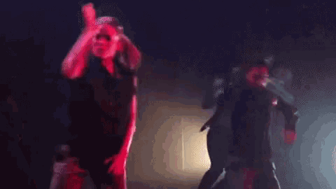 a couple of people are dancing on a stage in the dark