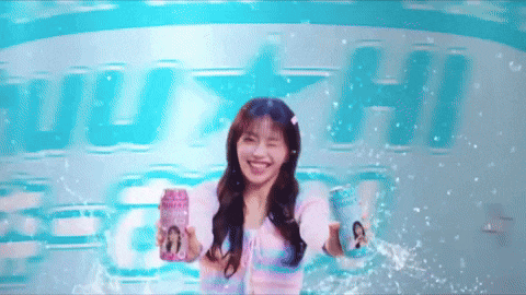 a girl is holding a can of soda in front of a sign that says " heineken "