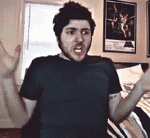 a man with a beard is standing in front of a bed with his arms outstretched