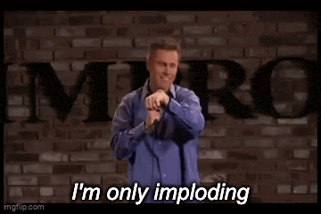 a man in a blue shirt is holding a microphone and saying i 'm only imploding