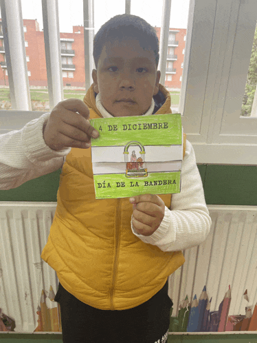 a young boy holds up a card that says 4 de diciembre