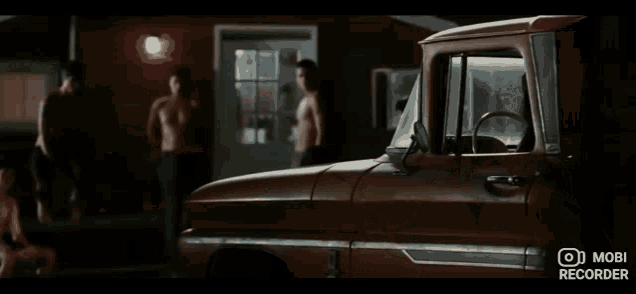 a group of naked men are standing in a room with a woman .