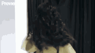 a woman with long hair is standing in front of a black curtain and the word previe is on the bottom of the screen