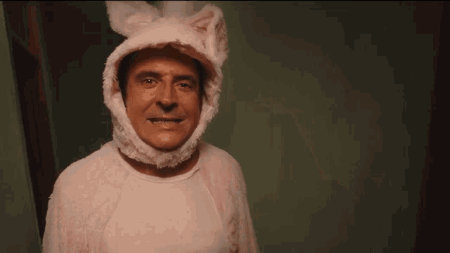 a man wearing a pink bunny costume with ears on his head