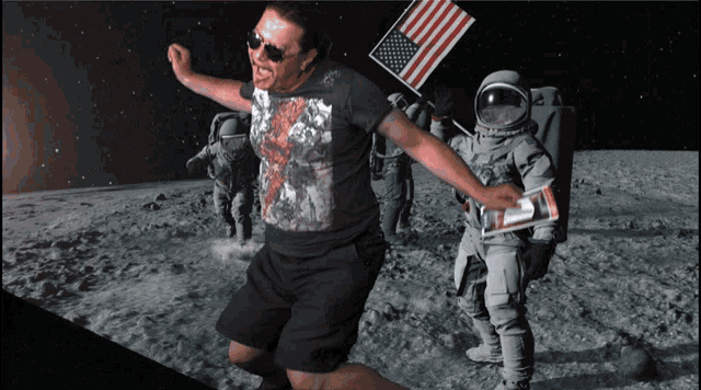 a man in a supreme shirt holds an american flag in front of an astronaut