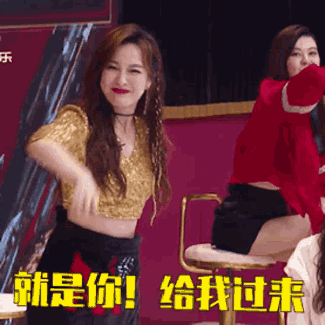 a woman in a gold top is dancing in front of a sign that says ' i 'm you ! '