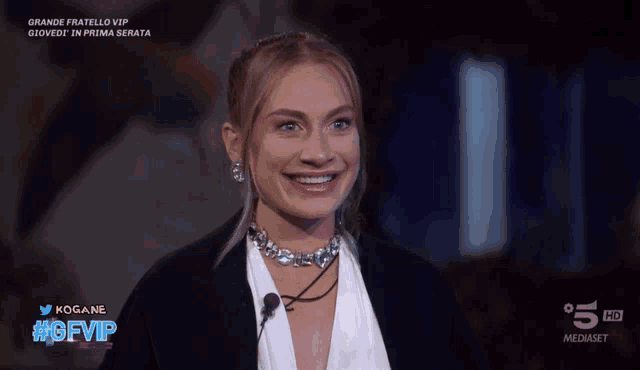 a woman is smiling in front of a tv screen that says 5 hd