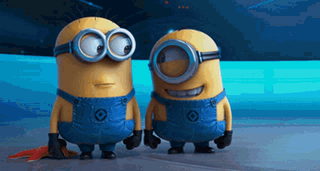 two minions wearing goggles and overalls are standing next to each other on a blue surface