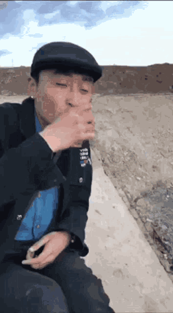 a man wearing a black hat is smoking a cigarette outside