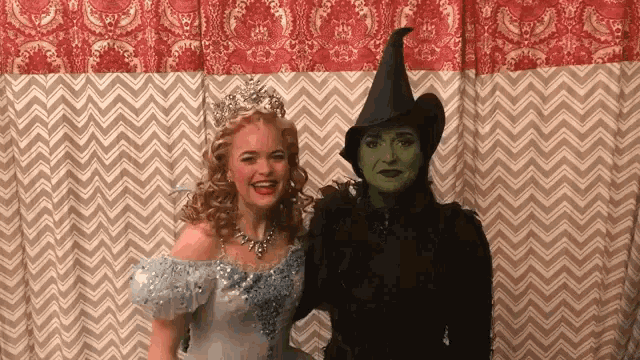 a witch and a fairy are posing for a picture .