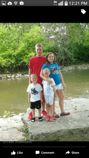 a group of children posing for a picture on a river bank