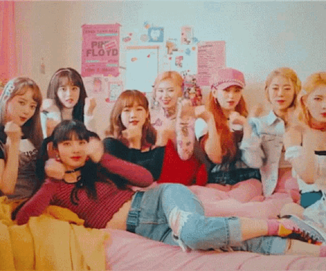 a group of girls are posing for a picture with a pink floyd poster in the background