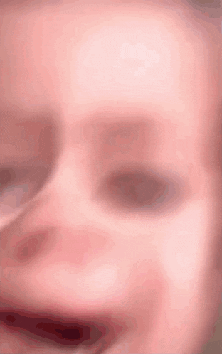 a close up of a baby 's face with a blurry eye