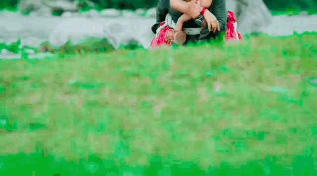 a man is carrying a woman on his back through a grassy field .