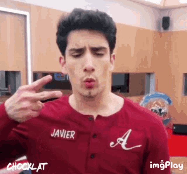 a young man in a red shirt with the name javier on it