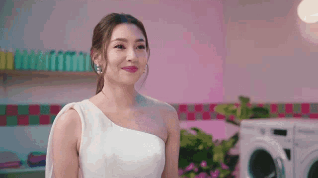 a woman in a white dress is standing in front of a washer and dryer