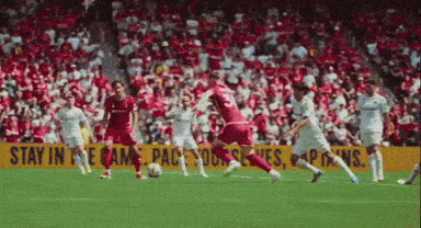 a soccer game is being played in front of a yellow sign that says stay in the game
