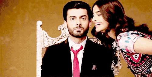 a man in a suit and tie stands next to a woman