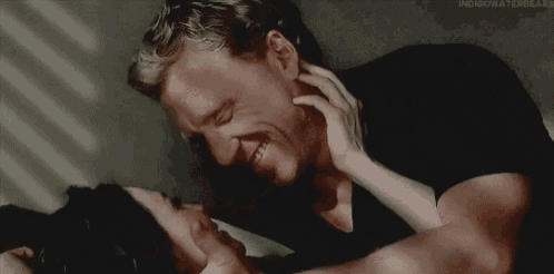 a man and a woman are kissing each other on the forehead .