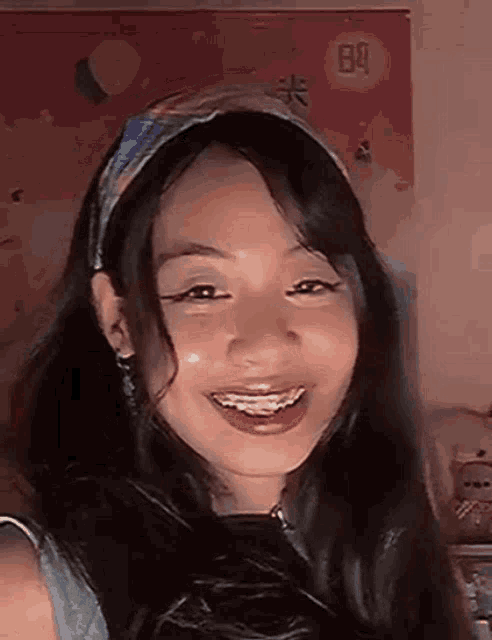 a girl with braces on her teeth is smiling for the camera