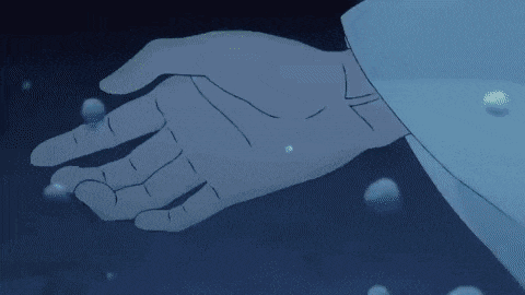 a close up of a person 's hand holding a pearl in the dark .