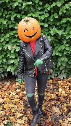 a person with a pumpkin head and a black jacket